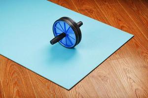 Blue roller for abs pumping classes on a blue fitness Mat. photo