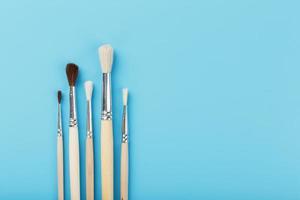 Brushes for drawing made of natural wood and wool. on a blue background. photo