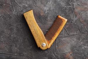 Wooden sandalwood comb on a black textured background. photo
