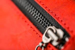 Zipper slider for a red suede leather bag. photo