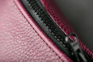 Zipper slider for a bag made of textured red leather. photo