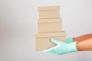 Delivery of a Parcel with gloves for protection against viruses and diseases on a white background. photo