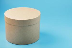Round cardboard box on a blue background, free space. photo