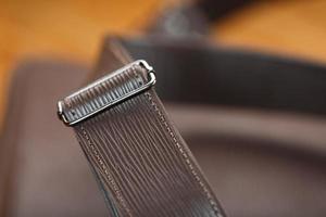 Close-up elements and details of the Backpack made of brown genuine leather on a wooden background. photo