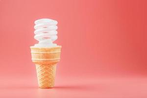 Energy-saving screw Light ice cream in a waffle cone on a pink background. photo