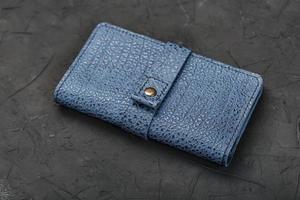 Blue leather wallet on a black textured background. photo