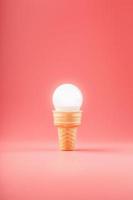 Light bulb ice cream in a waffle Cup on a pink background. photo