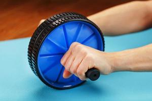 Roll for training the press in the hands on a blue rug. photo