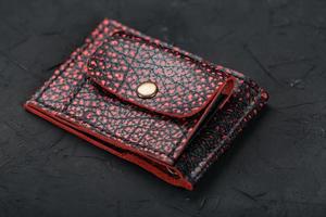 Red and black leather wallet on a black background. photo