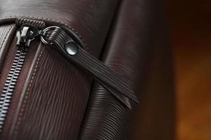 Close-up elements and details of the Backpack made of brown genuine leather on a wooden background.