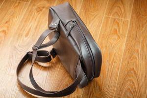 Backpack made of brown genuine leather on a wooden background. photo