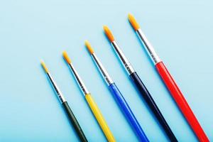 Multi-colored paint Brushes on a blue background. photo