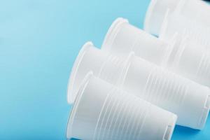 Plastic cups of disposable tableware on a blue background. photo