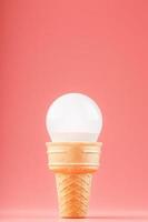 Light bulb ice cream in a waffle Cup on a pink background. photo