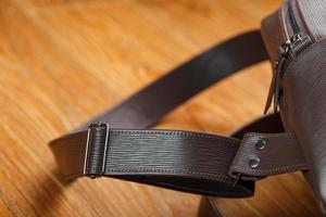 Close-up elements and details of the Backpack made of brown genuine leather on a wooden background. photo