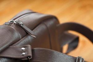 Close-up of the elements of the bag, backpack made of genuine leather with belt buckles and locks. photo