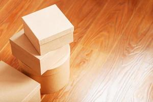 Cardboard mail boxes on the wooden floor of different shapes. photo