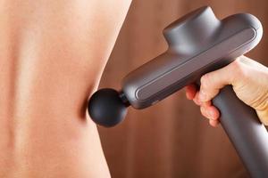 Electric Massager drill in hand massages your back. photo