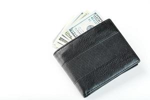 Black wallet with genuine leather dollars on an isolated white background. photo
