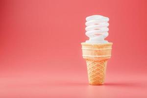 Energy-saving screw Light ice cream in a waffle cone on a pink background. photo