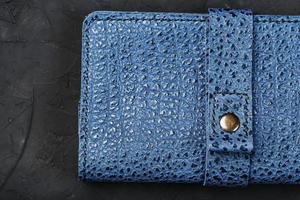 Blue leather wallet on a black textured background. photo