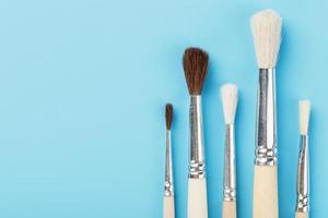 Brushes for drawing made of natural wood and wool. on a blue background. photo