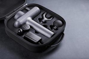 Electric massager Machine for body massage in a case on a black background. photo