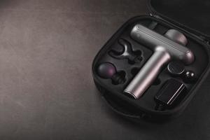 Electric massager Machine for body massage in a case on a black background. photo
