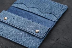 Blue leather wallet on a black textured background. photo