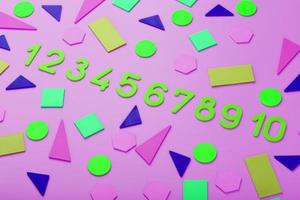 Colorful figures and numbers for children on a pink background. A tool for developing children's thinking. photo