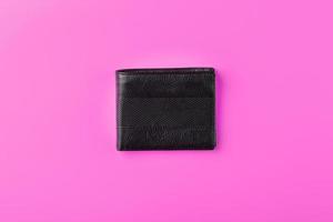 Black wallet on pink background. Symbol of prosperity and prosperity. photo