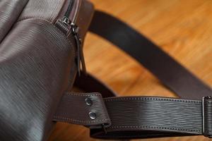 Close-up of the elements of the bag, backpack made of genuine leather with belt buckles and locks. photo