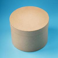 Round cardboard box on a blue background, free space. photo