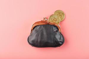 Classic black wallet with bitcoin coins on a pink background. photo