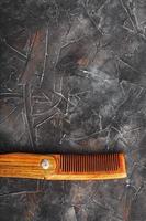 Folding wooden comb on a black background. photo