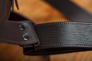 Close-up elements and details of the Backpack made of brown genuine leather on a wooden background. photo