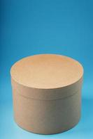 Round cardboard box on a blue background, free space. photo