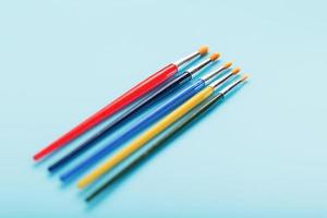 Multi-colored paint Brushes on a blue background. photo