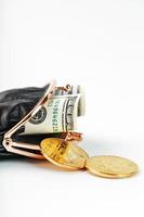 An open black wallet with money, dollars and bitcoin coins on a white background. photo