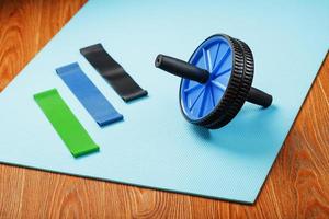 Set of Roll for body muscles, elastic bands for fitness on a blue training Mat. photo