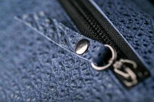 Zipper slider for a blue textured leather bag. photo