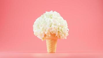 flores blancas en un cono de gofre de helado sobre un fondo rosa. foto