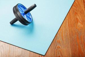 Blue roller for abs pumping classes on a blue fitness Mat. photo