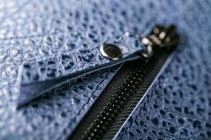 Zipper slider for a blue textured leather bag. photo
