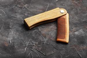 Wooden sandalwood comb on a black textured background. photo