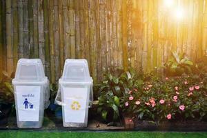 Plastic bins in front of the bamboo wall in the park in Chiang Rai, Thailand. Thai wordings of the left bin mean for throwing general waste. the right bin mean for throwing recycle waste. photo