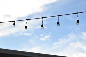 Wire of lignting bulbs tied around the outdoor area of the house to decorate and to celebrate the special events, soft and selective focus. photo