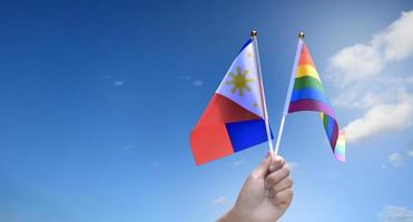 Rainbow flag and Philipines national flag holding in hand, soft and selective focus, concept for celebration of lgbtq in pride month around the world. photo