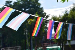 Lgbtq flags were hung on wire to decorate outside balcony of restaurant, soft and selective focus, concept for LGBTQ plus gender celebrations in pride month around the world. photo