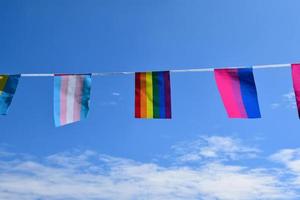 Las banderas lgbtq se colgaron en un cable contra el cielo azul en un día soleado, enfoque suave y selectivo, concepto para celebraciones de género lgbtq en el mes del orgullo en todo el mundo. foto
